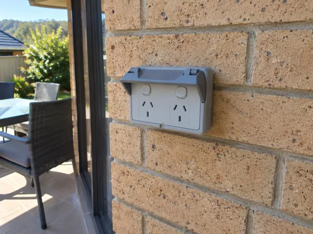 Outdoor double power point mounted on a brick wall beside a patio door in Morisset
